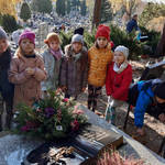 uczniowie z wiązankami na cmentarzu